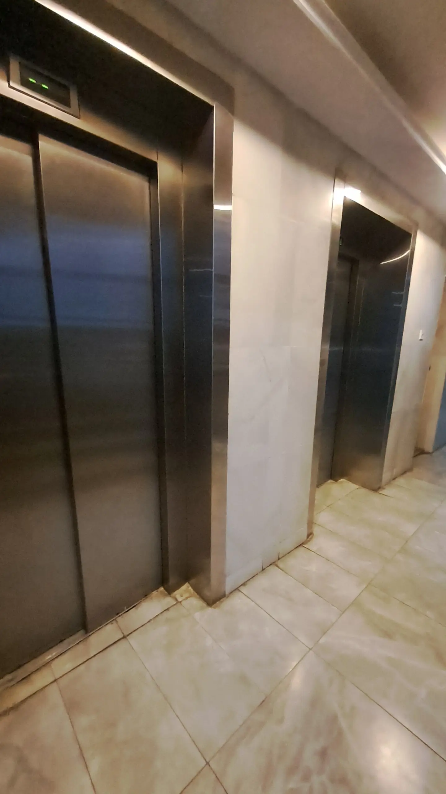Building lobby with dual elevators and polished floor