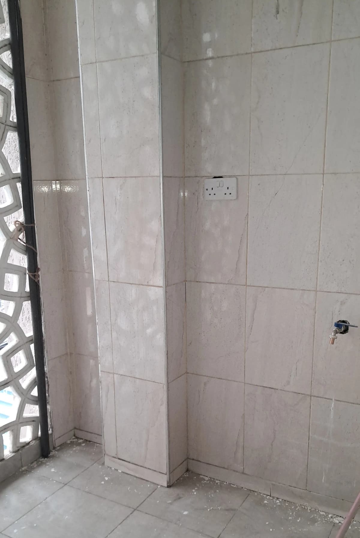 Tiled bathroom with shower area and wall outlets