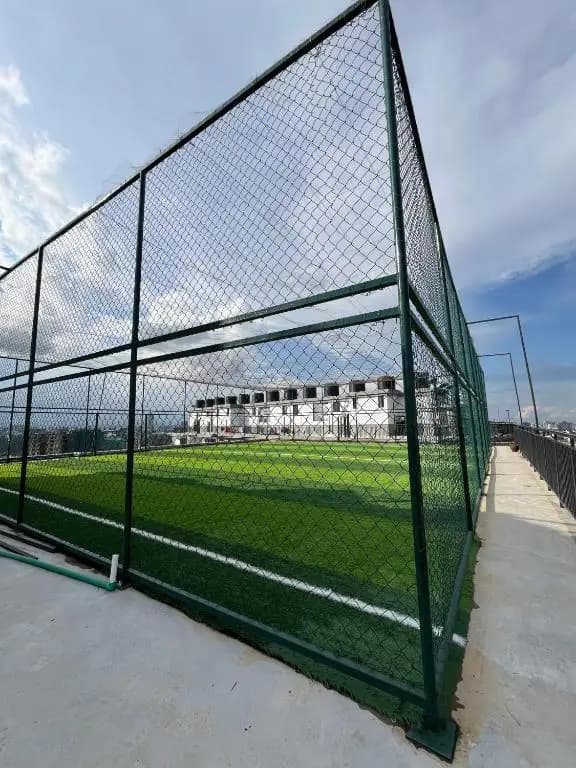 Rooftop artificial turf football pitch with green fencing