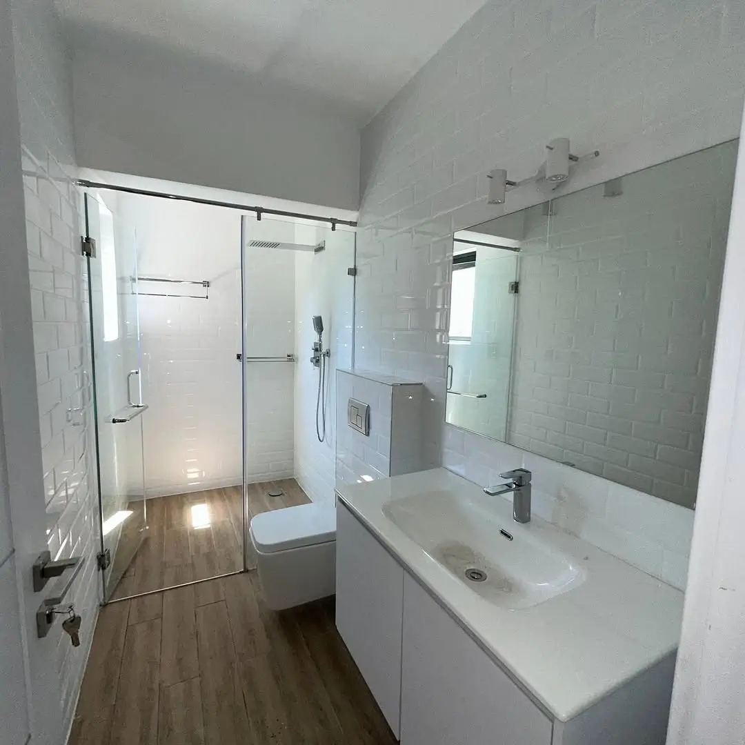 Modern bathroom with walk-in shower, dual vanity, wood flooring