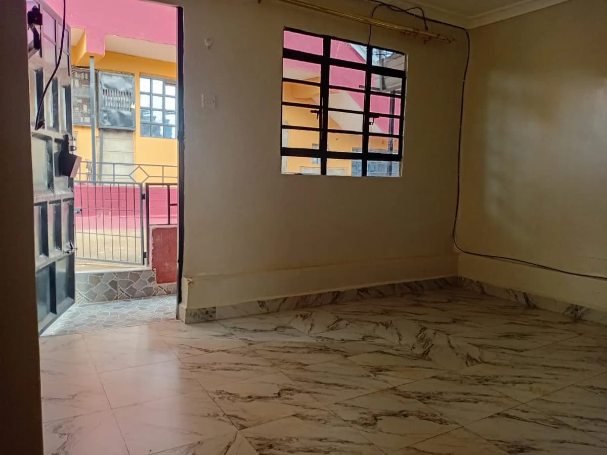 Bare living space with tiled flooring and high windows