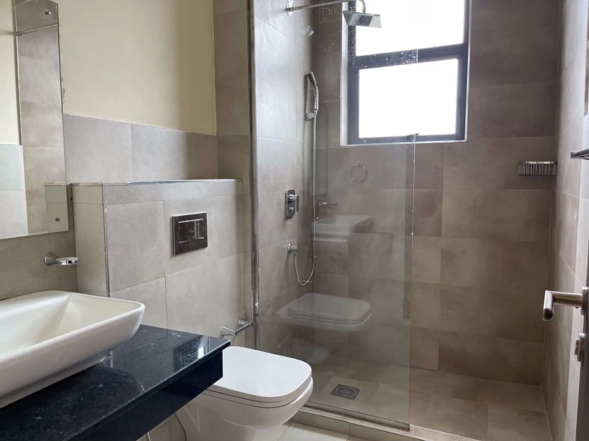 Modern bathroom with walk-in shower, vessel sink, dark countertop