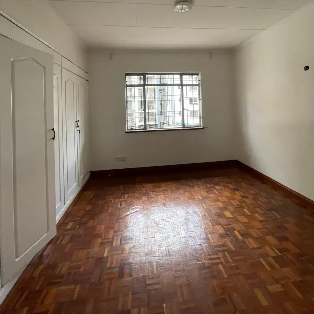 Empty bedroom with wooden parquet floor and wardrobe