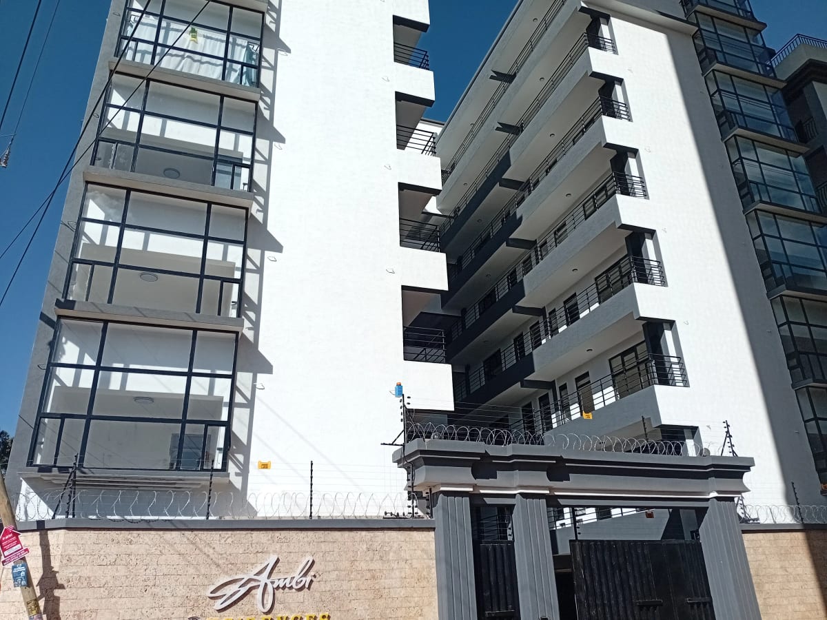 Modern apartment building facade with gated entrance and balconies