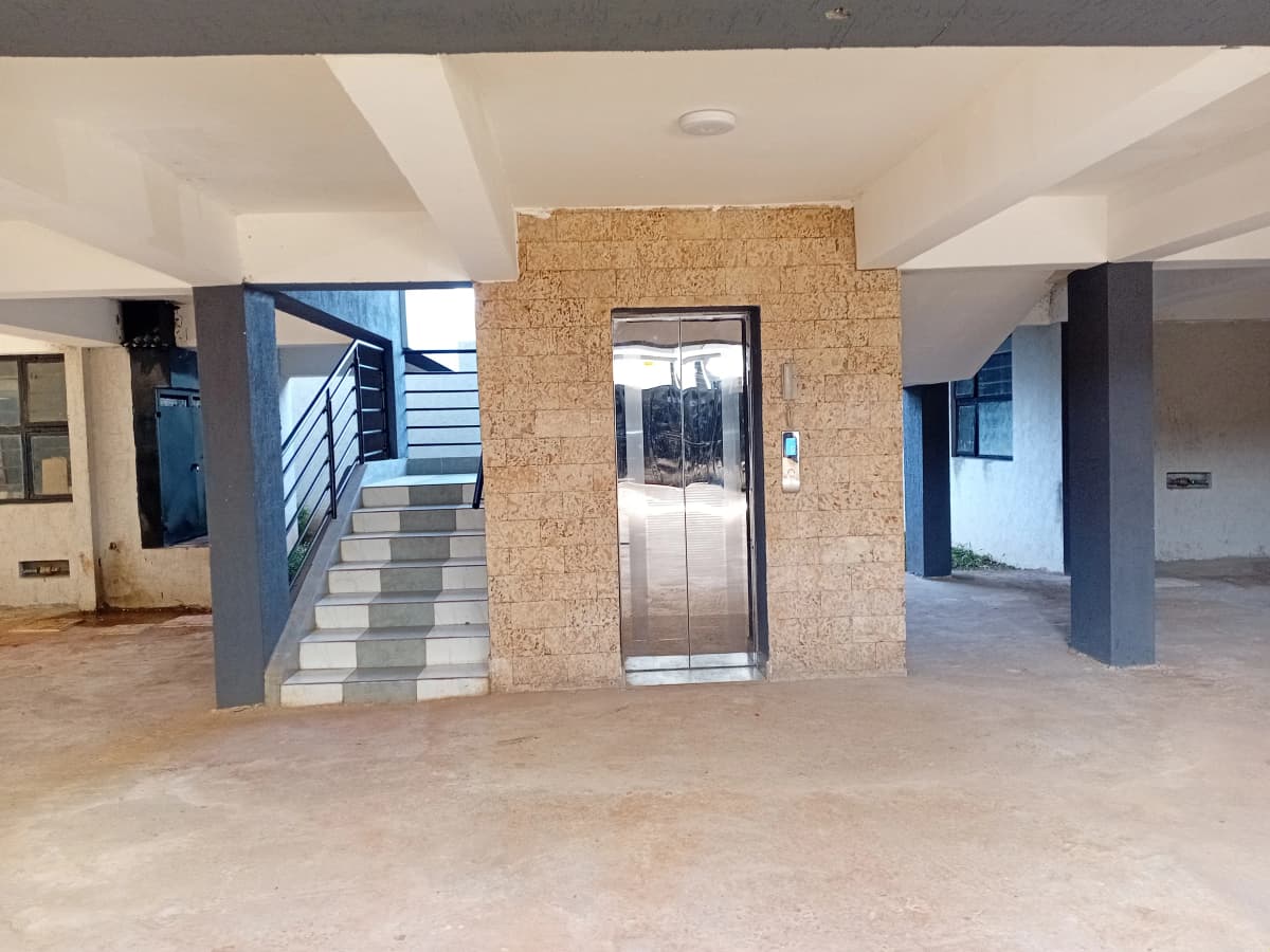 Modern building lobby with lift, cork feature wall, staircase