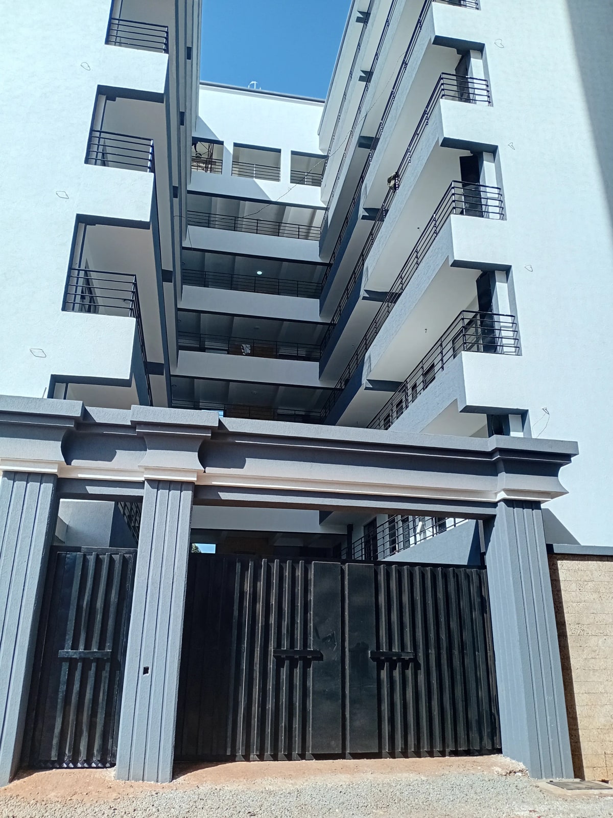 Modern apartment building facade with metal gate entrance