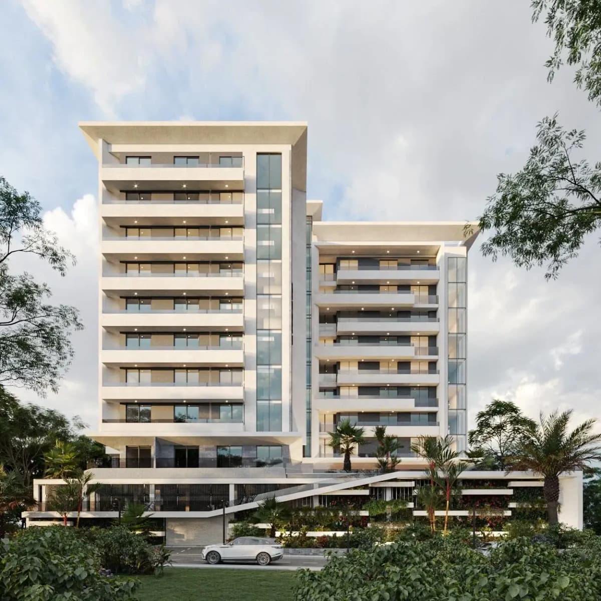 Modern white high-rise apartment block with landscaped grounds