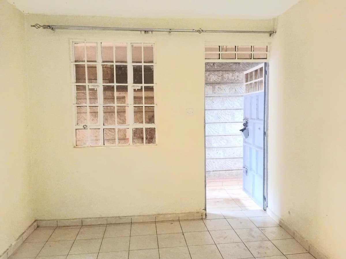 Empty living room with tiled floor and glass door access