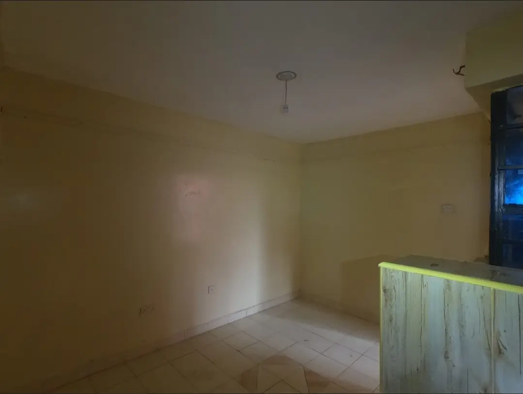 Empty bedroom with pale yellow walls and pendant light