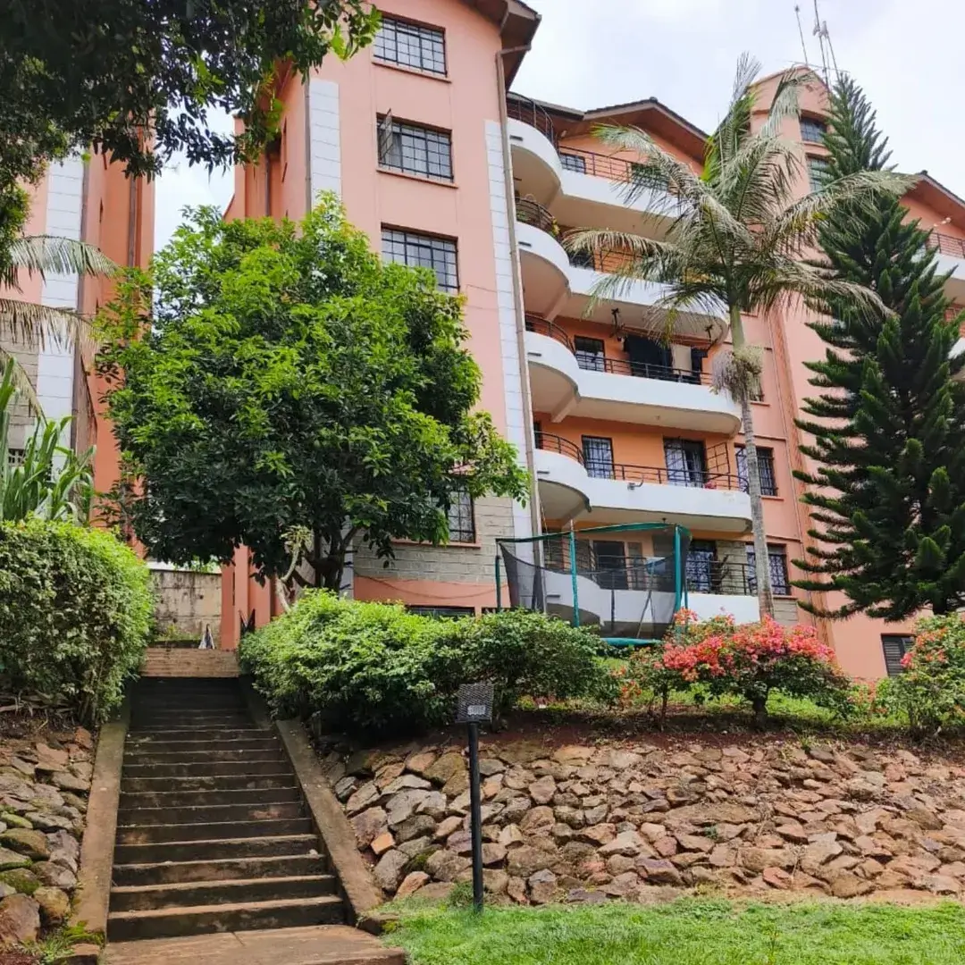 Multi-story residential building with terracotta facade and landscaped grounds