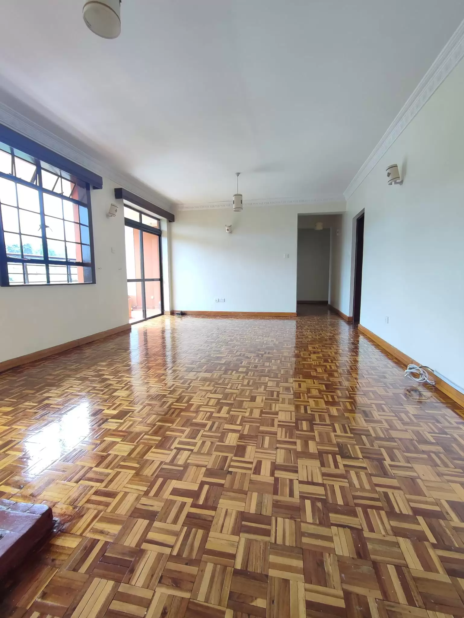 Spacious living room with parquet flooring and natural light