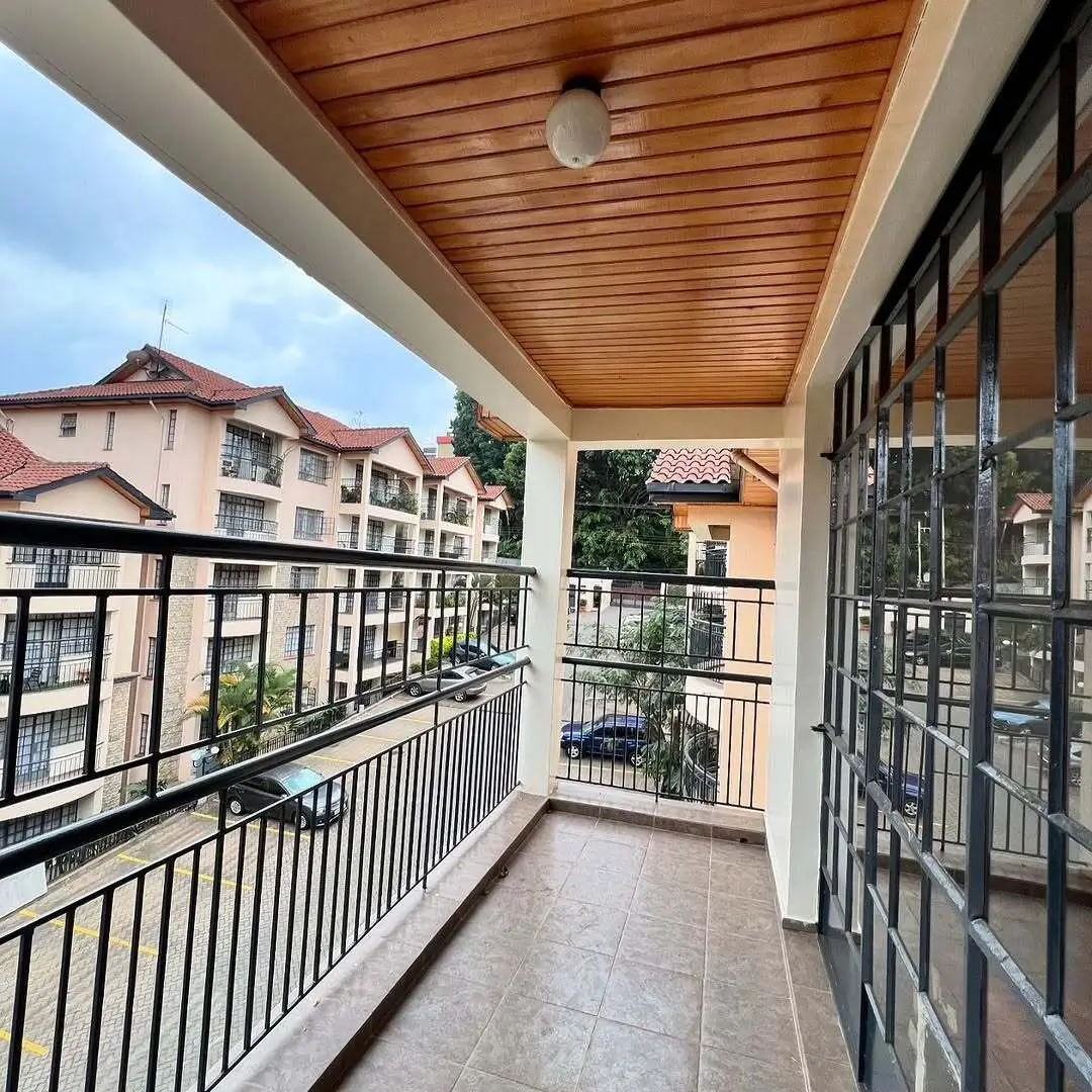 Spacious covered balcony with wood ceiling overlooking residential compound