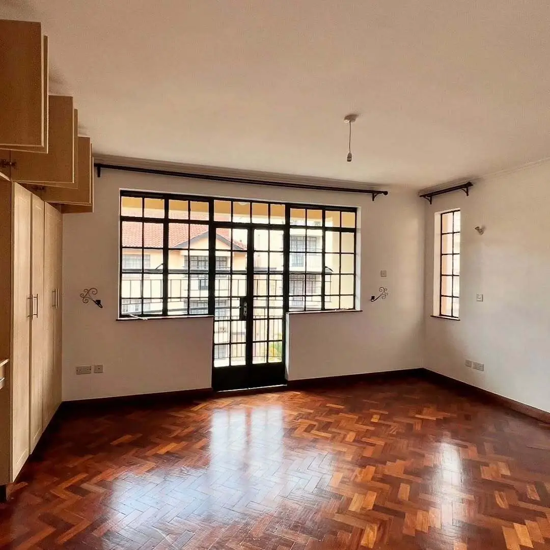 Spacious living room with herringbone wood floors and grid windows