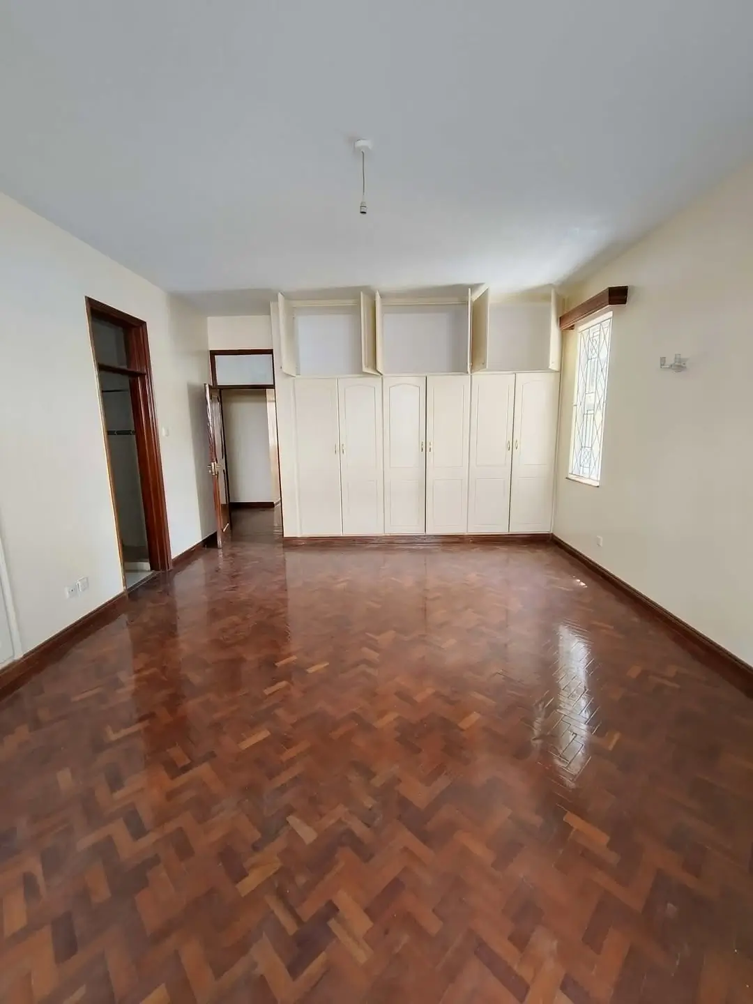 Spacious bedroom with herringbone floor and built-in wardrobes
