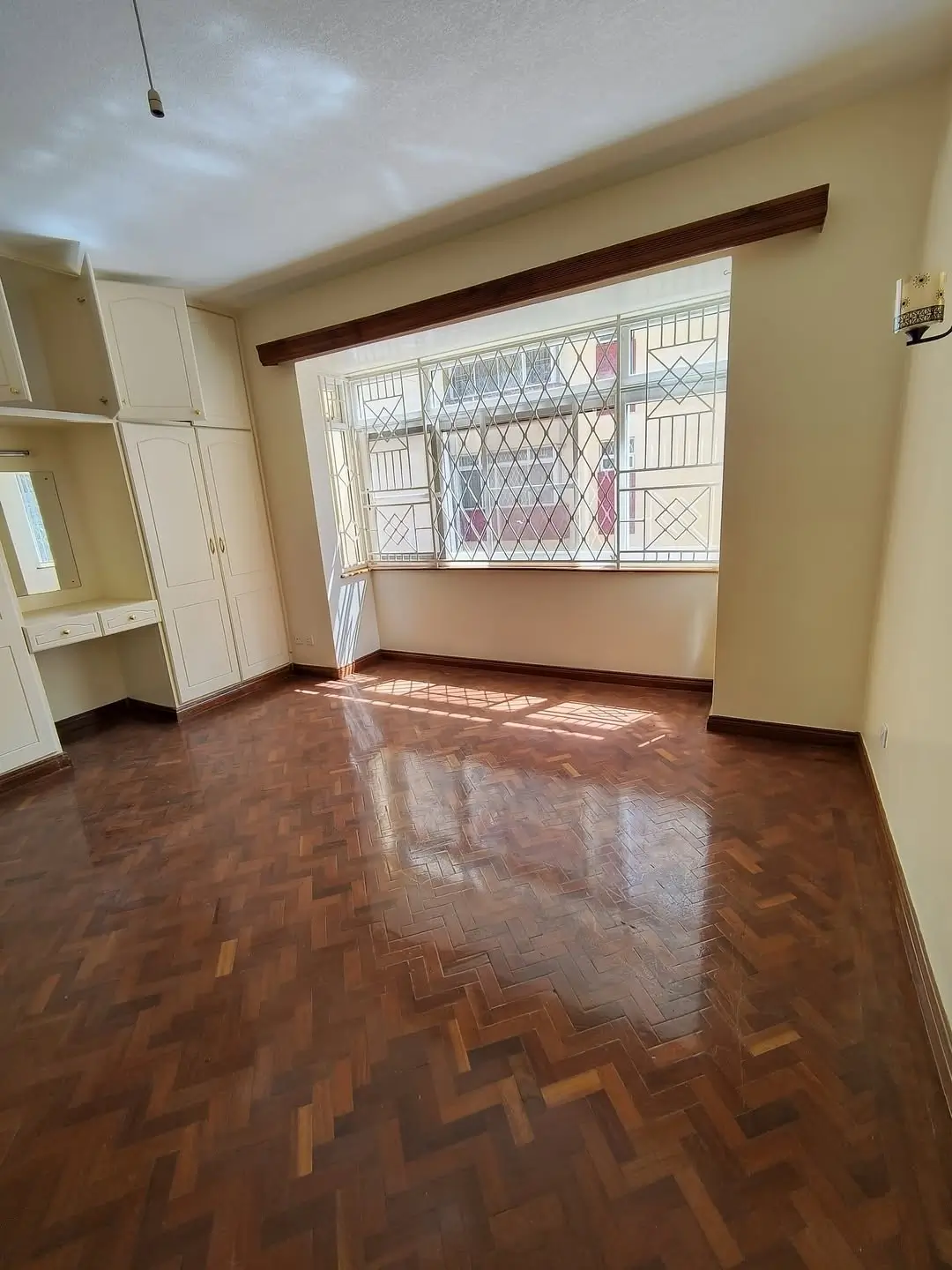 Spacious living room with herringbone wooden flooring and natural light