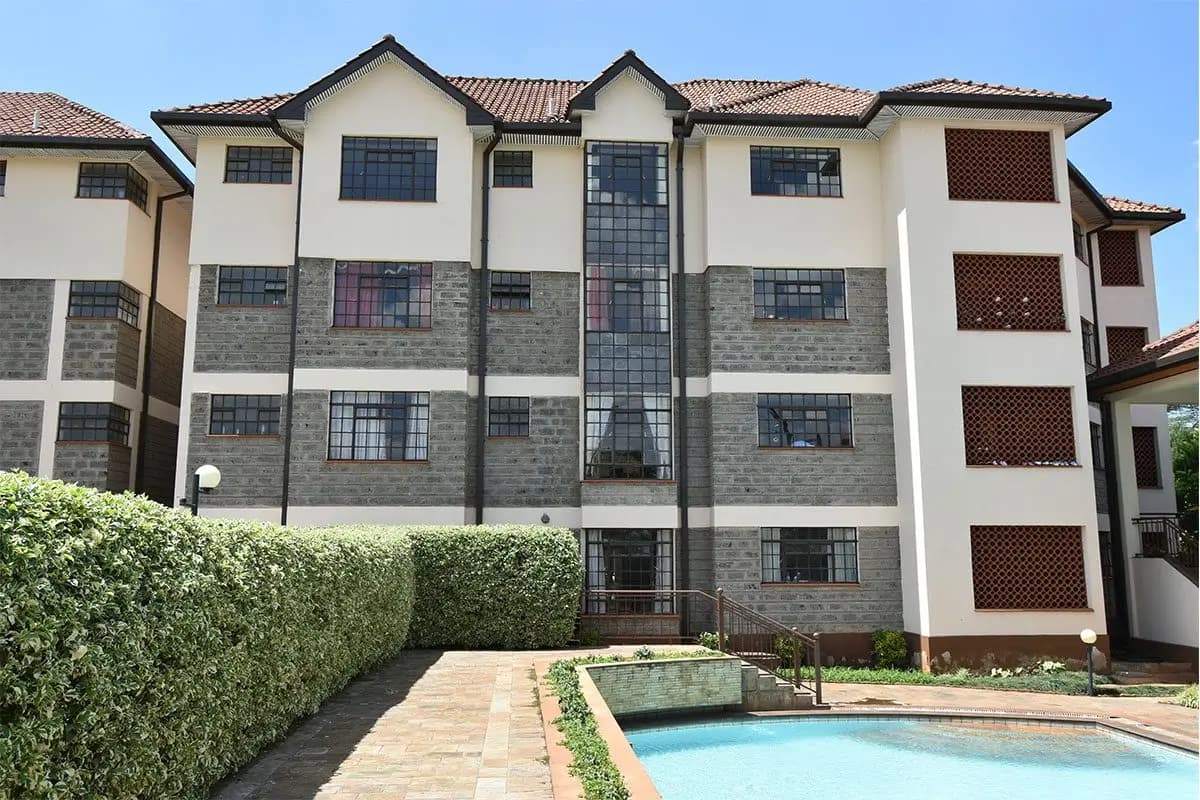 Multi-story residential building with pool and manicured grounds