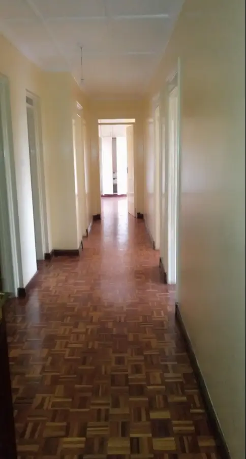 Long corridor with wooden parquet flooring and white walls