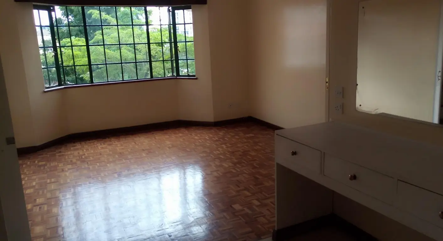 Spacious living room with large windows and parquet flooring