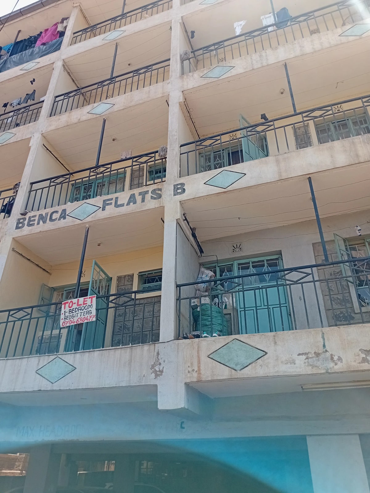 Multi-story residential building facade with balconies and signage