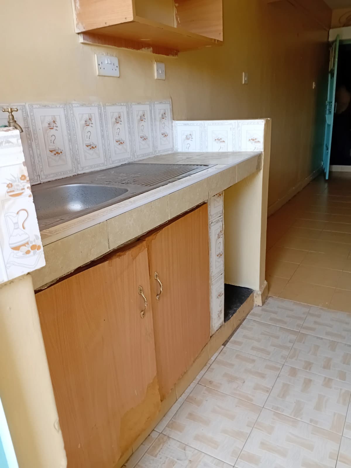 Basic kitchen with stainless steel countertop and wooden cabinets