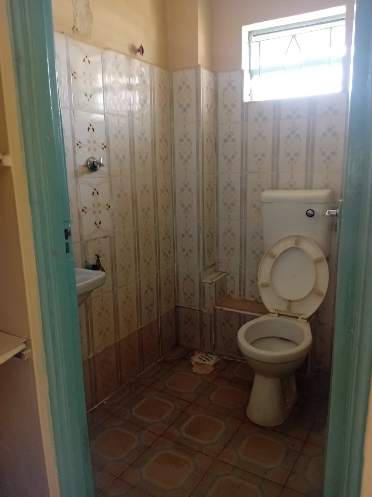 Simple bathroom with toilet, sink, and shower enclosure