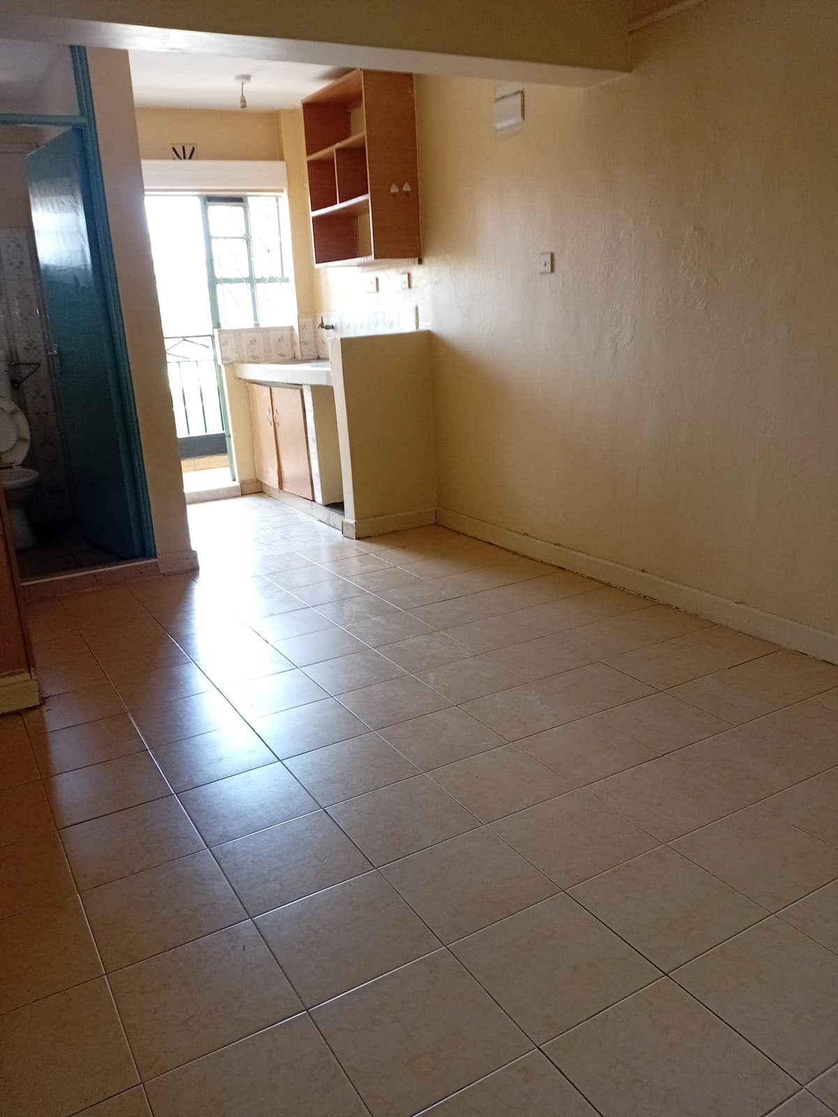 Open-plan living and kitchen area with tiled flooring