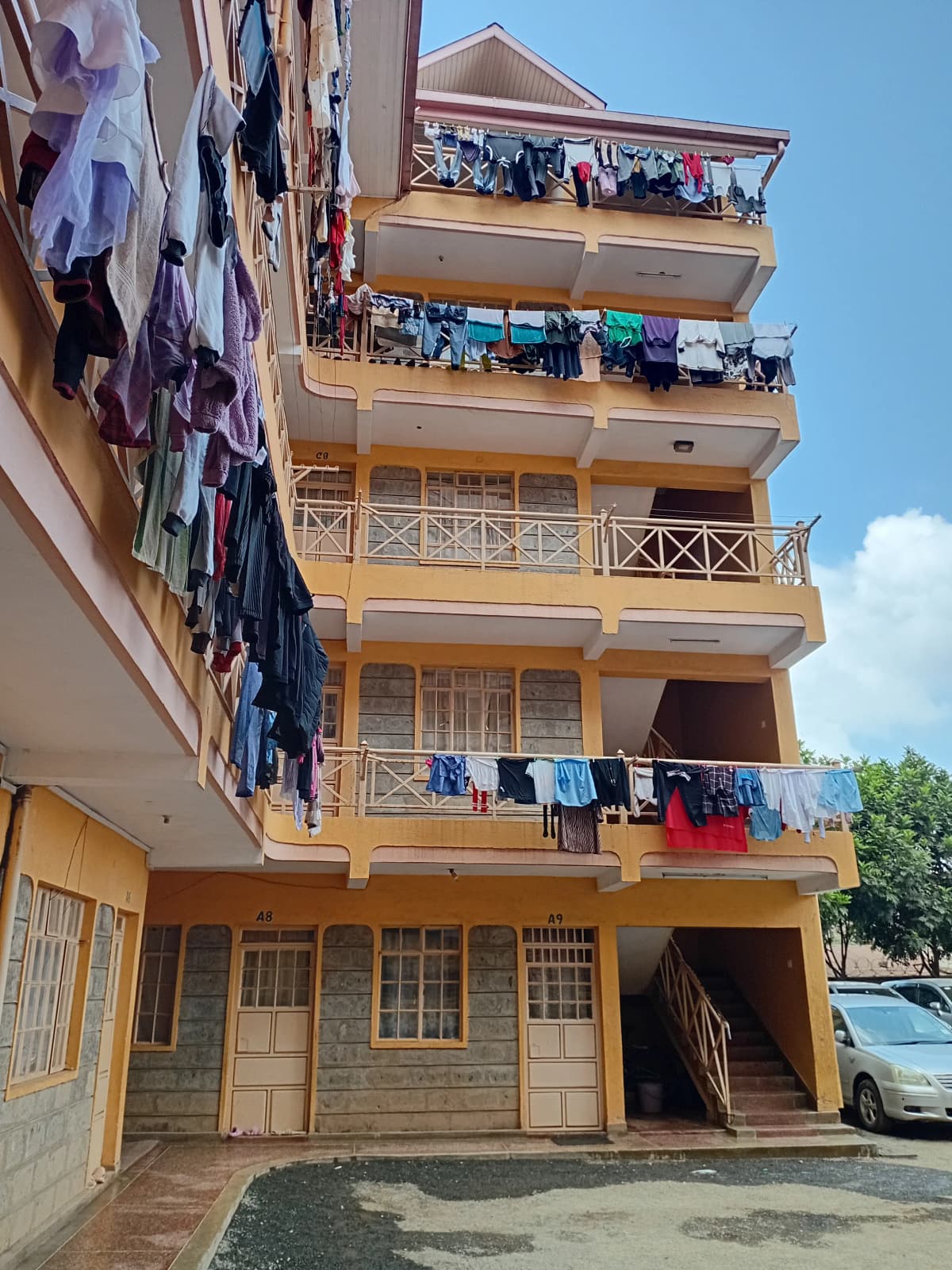 Yellow residential building facade with multiple balconies