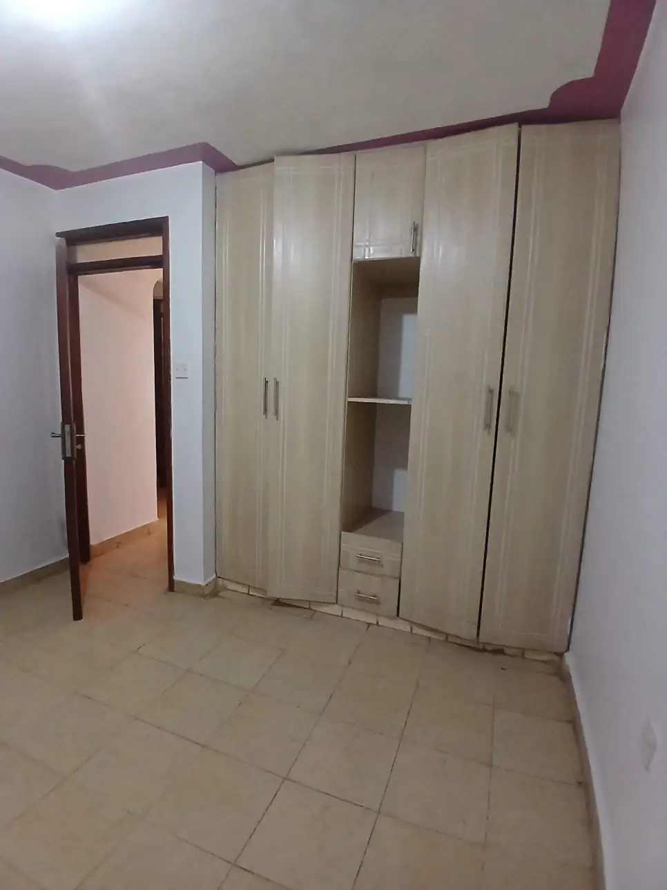 Spacious bedroom with built-in wardrobe and tiled flooring