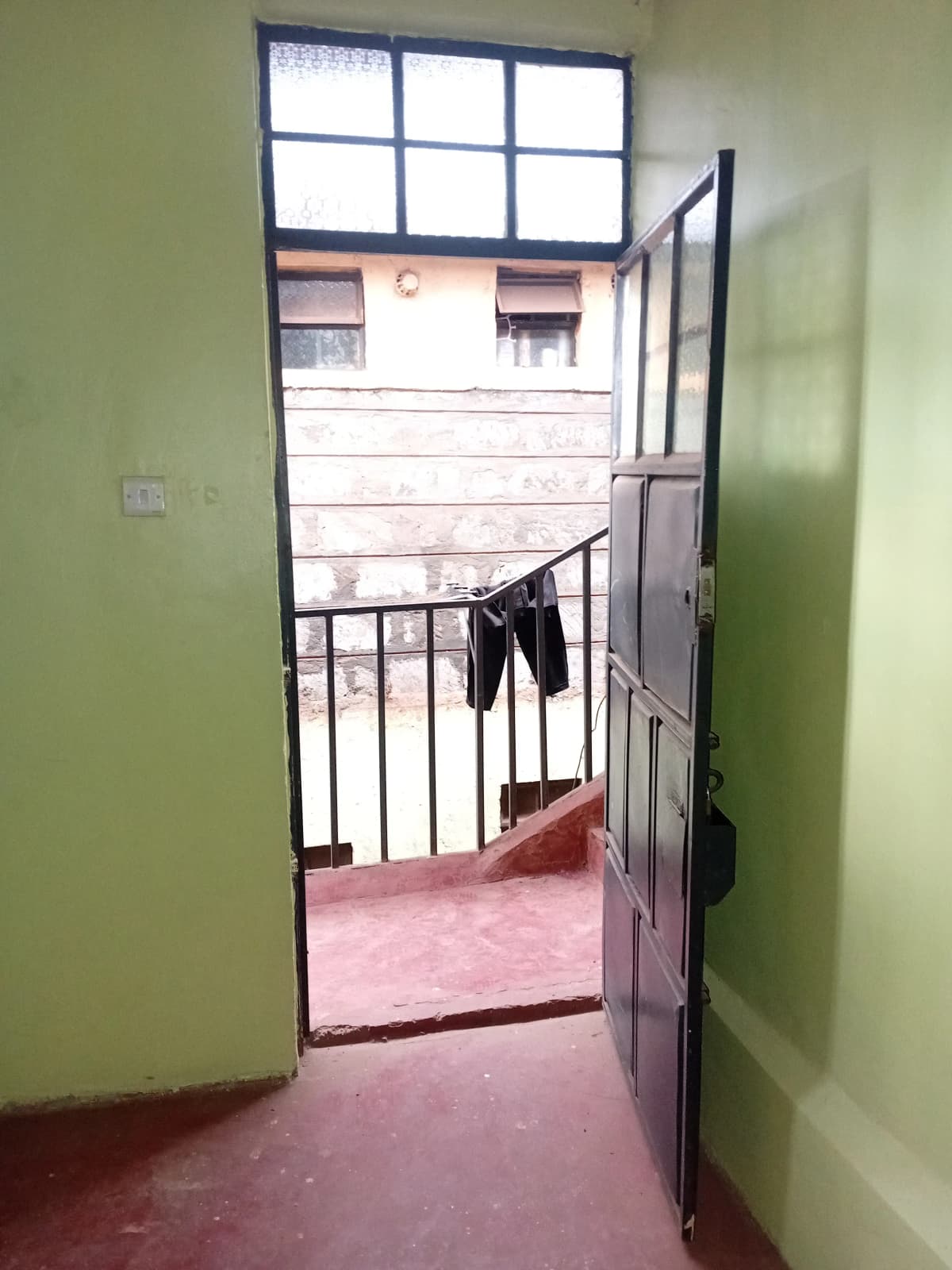 Outdoor balcony with metal railing and staircase access