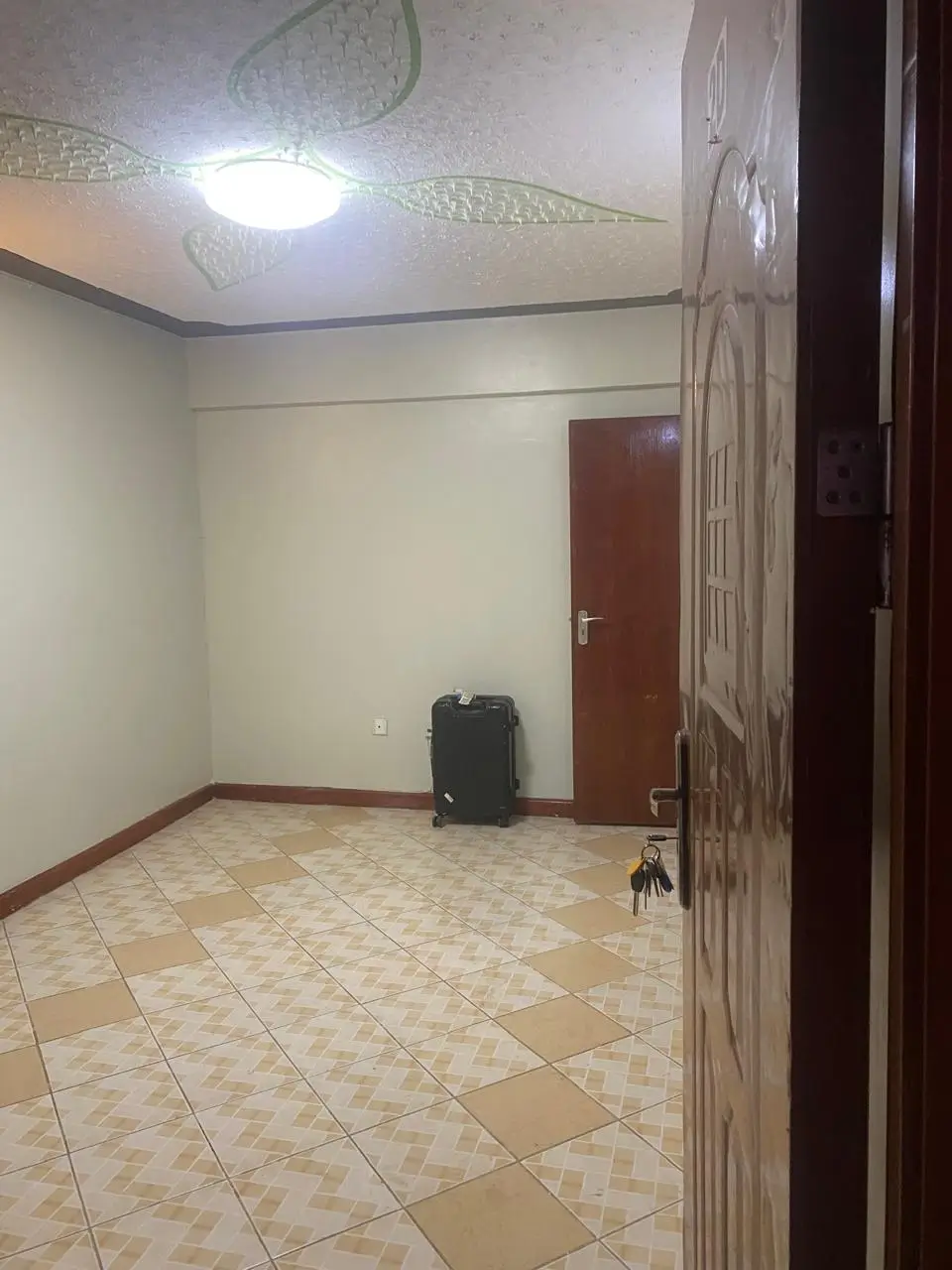Empty bedroom with tiled floor and wooden door frame