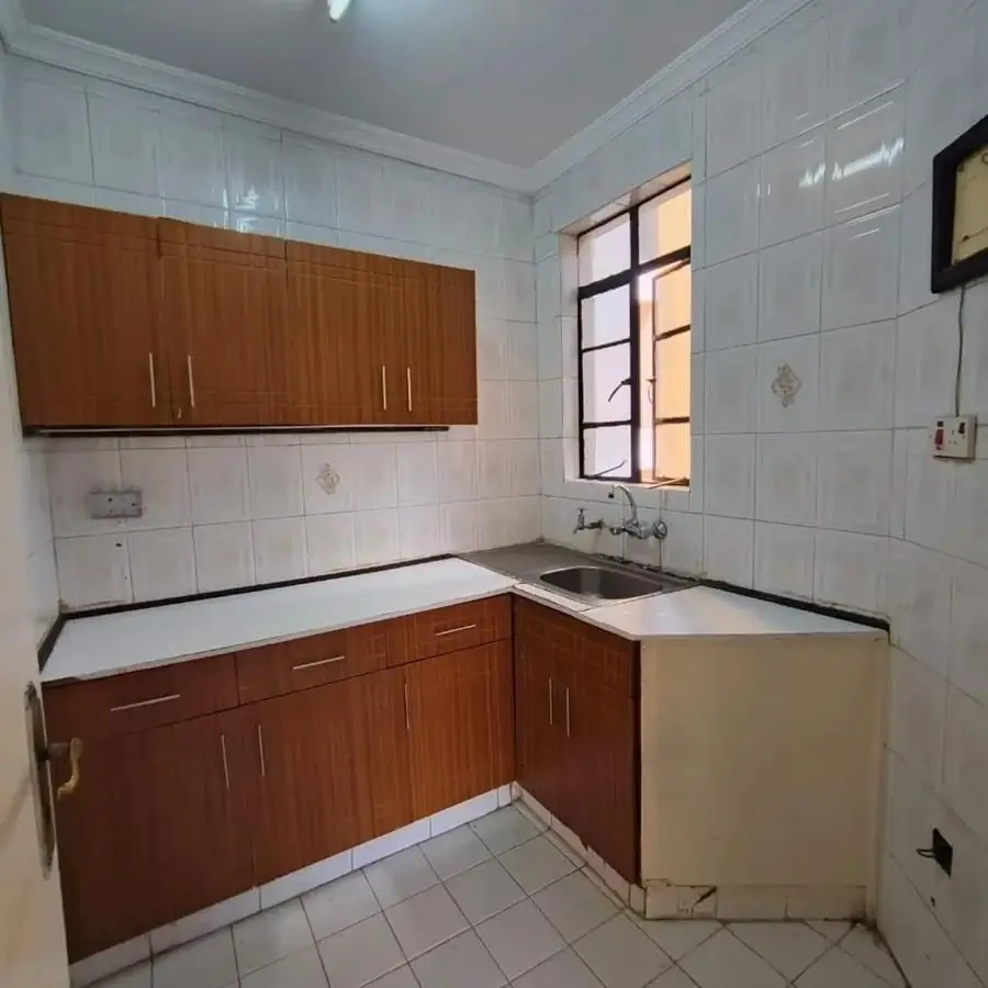 Compact kitchen with wooden cabinets and white tile walls