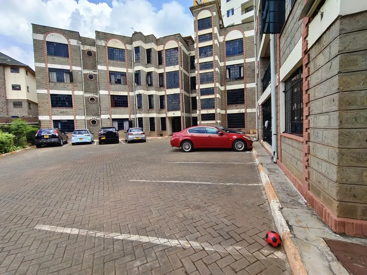 Multi-story residential building with paved parking compound