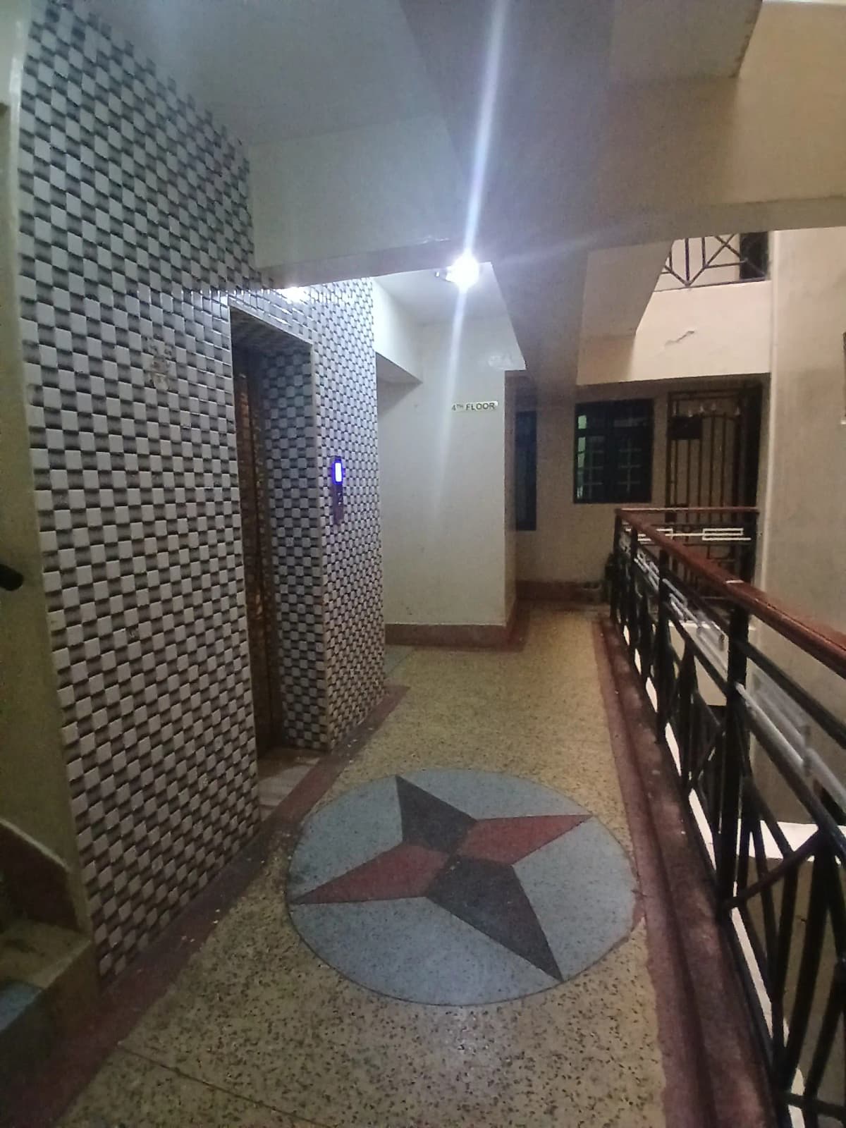 Building lobby with geometric tile floor and staircase access