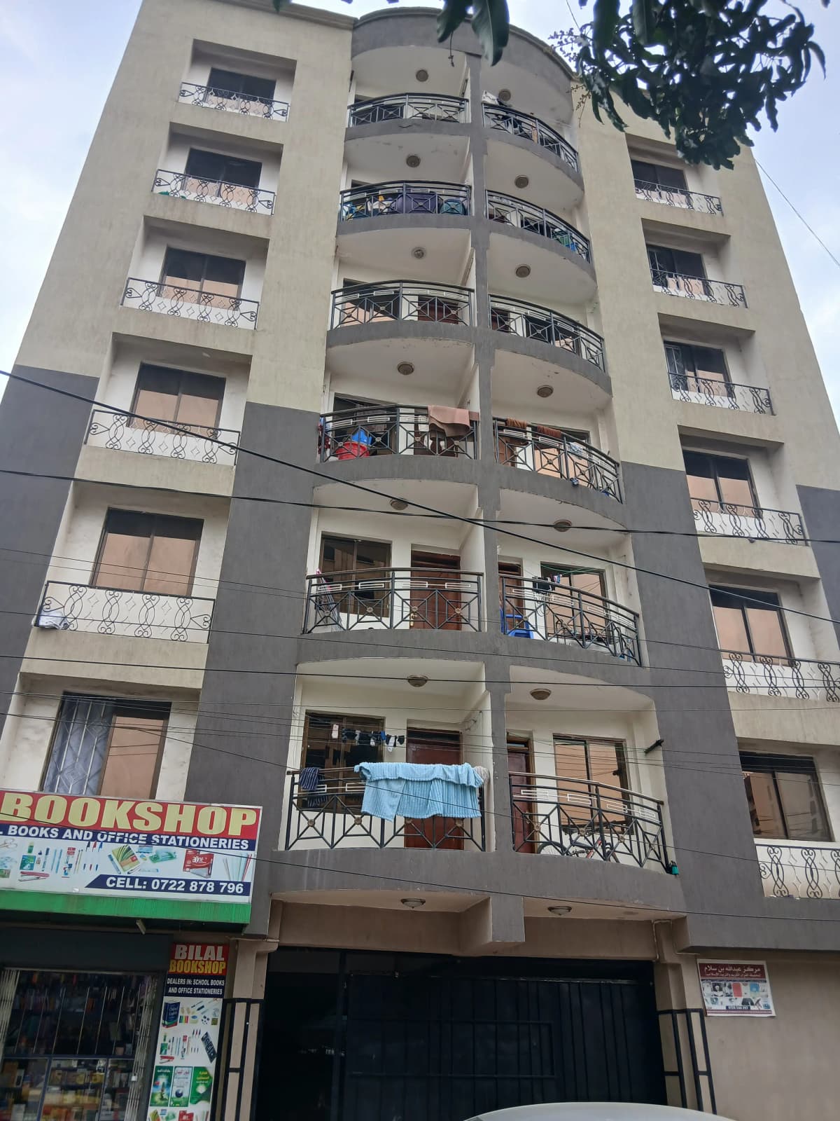 Multi-story residential building facade with balconies and ground-floor retail