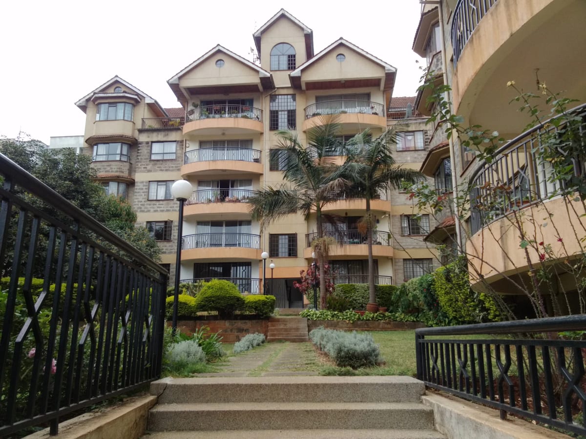 Multi-story residential building with manicured compound grounds
