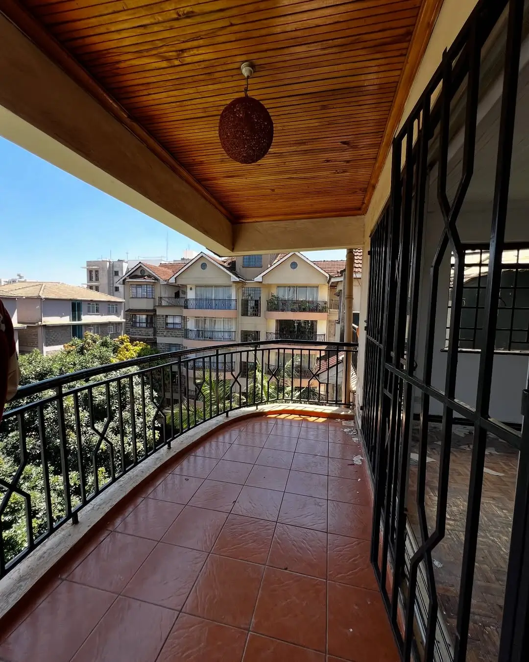 Spacious balcony with wooden ceiling and neighborhood views