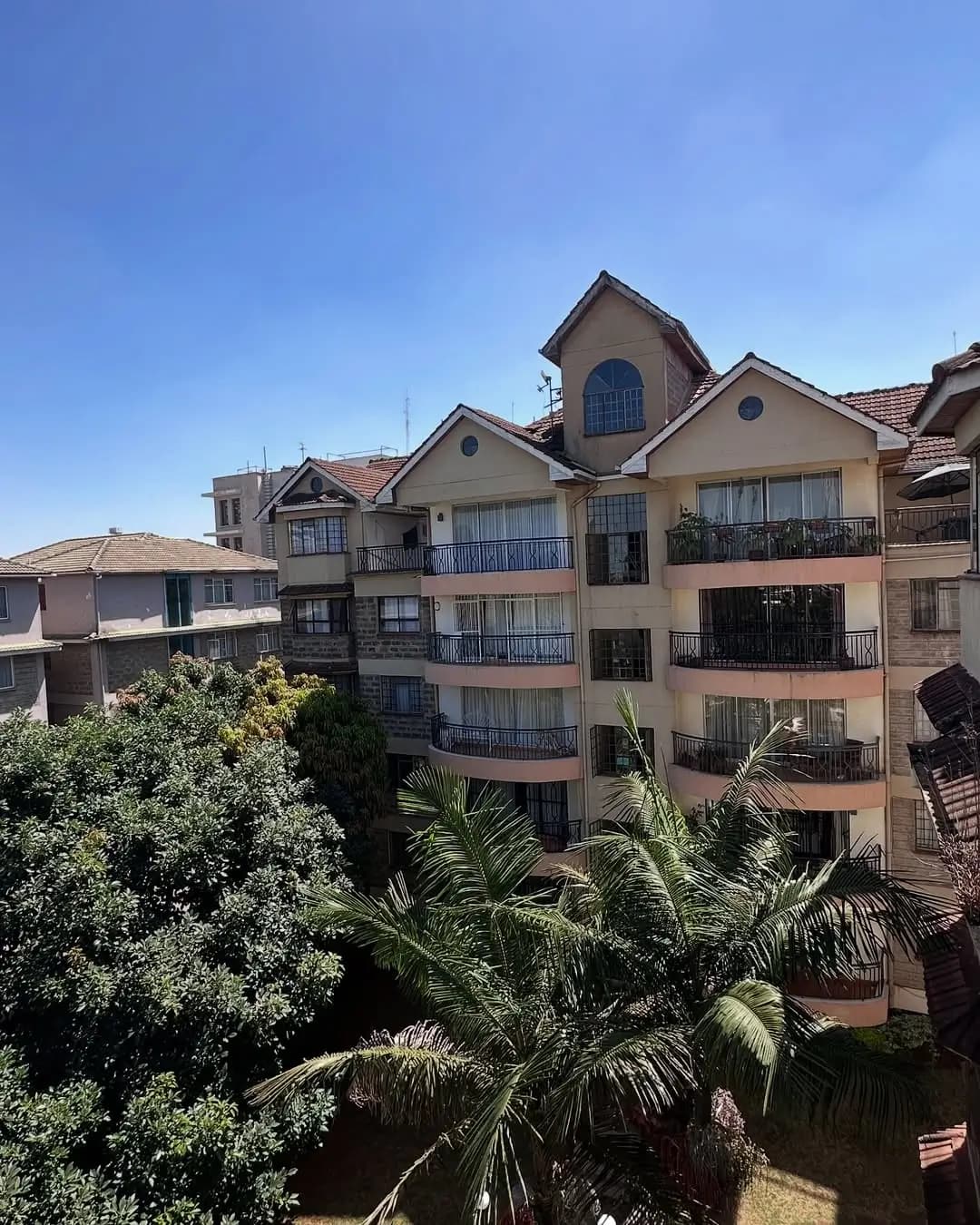 Multi-story residential building facade with balconies and landscaping