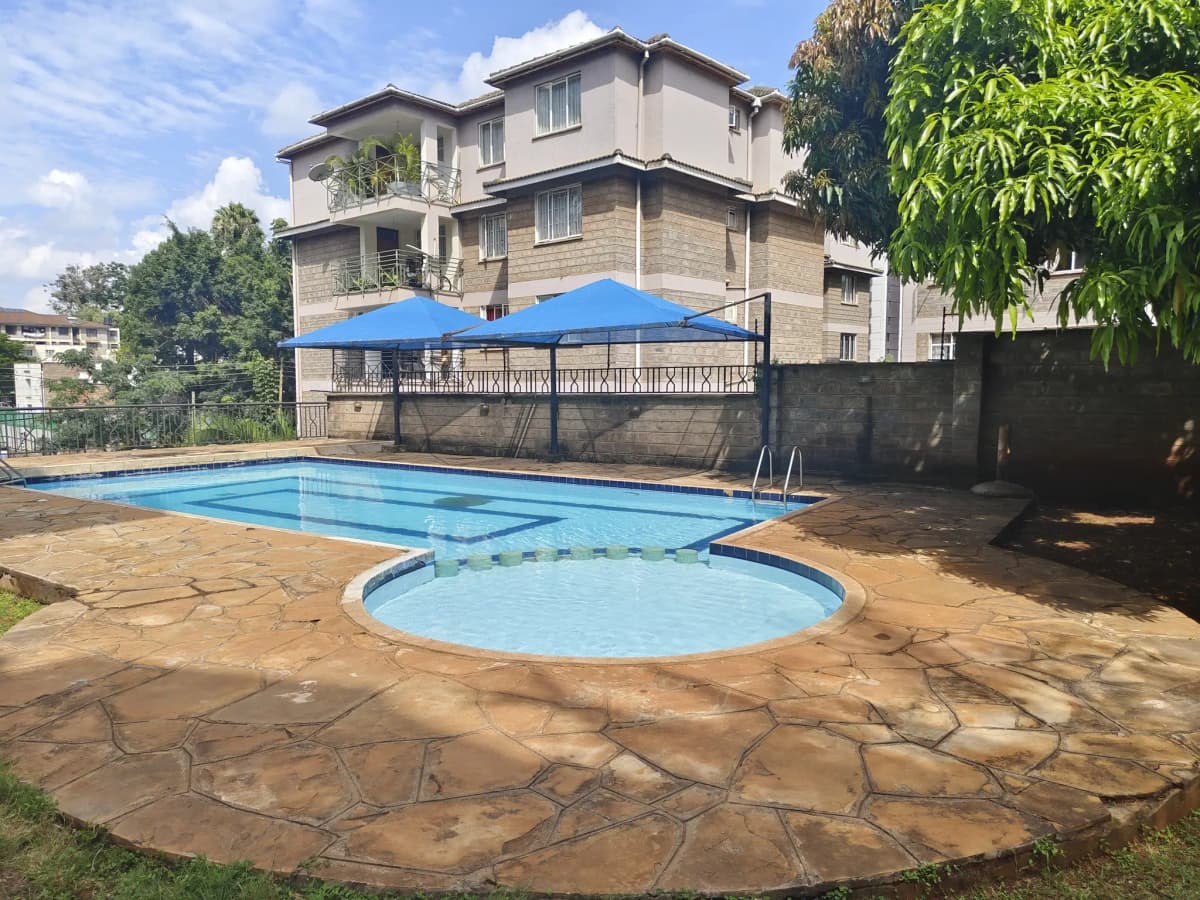 Rectangular swimming pool with jacuzzi and blue umbrella shade