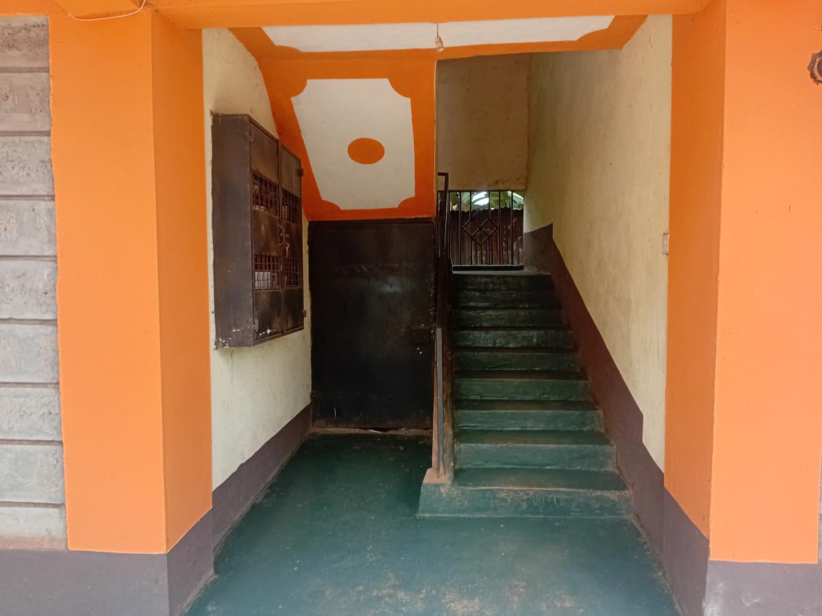 Building entrance corridor with stairs, orange painted walls