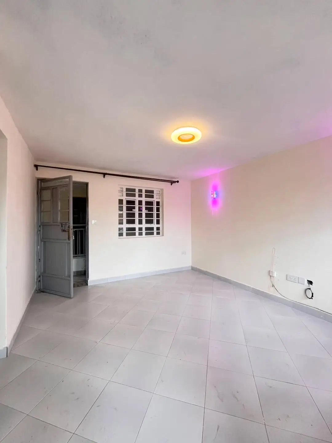 Empty living room with tiled floor and accent lighting