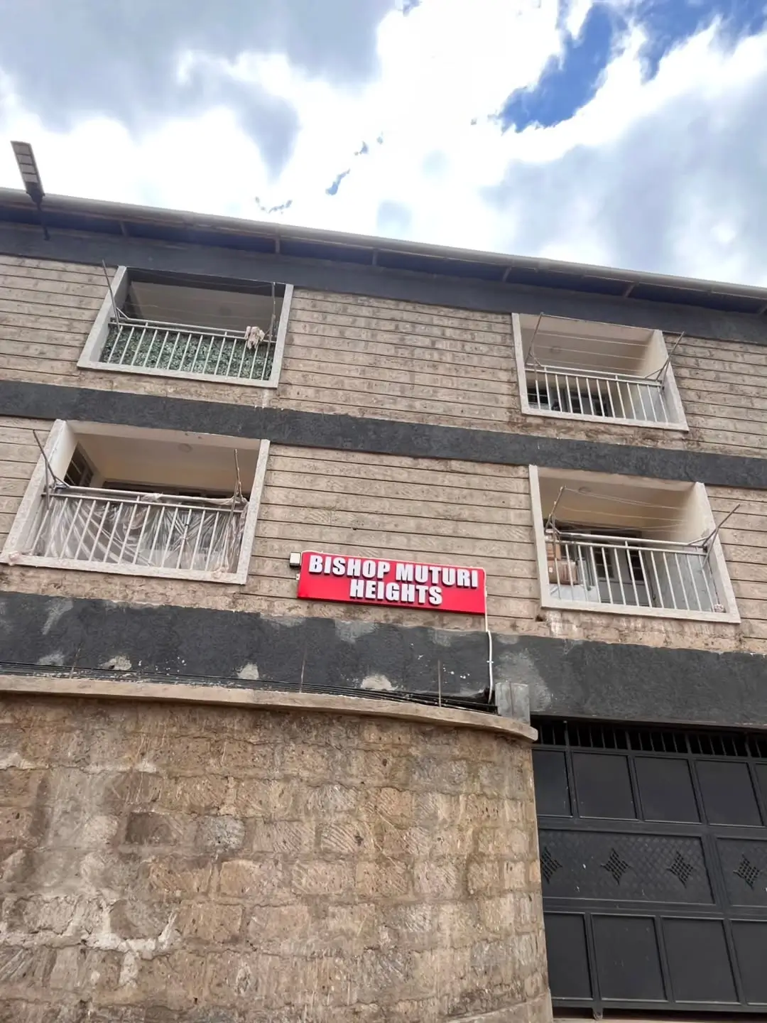 Multi-story residential building facade with balconies and signage