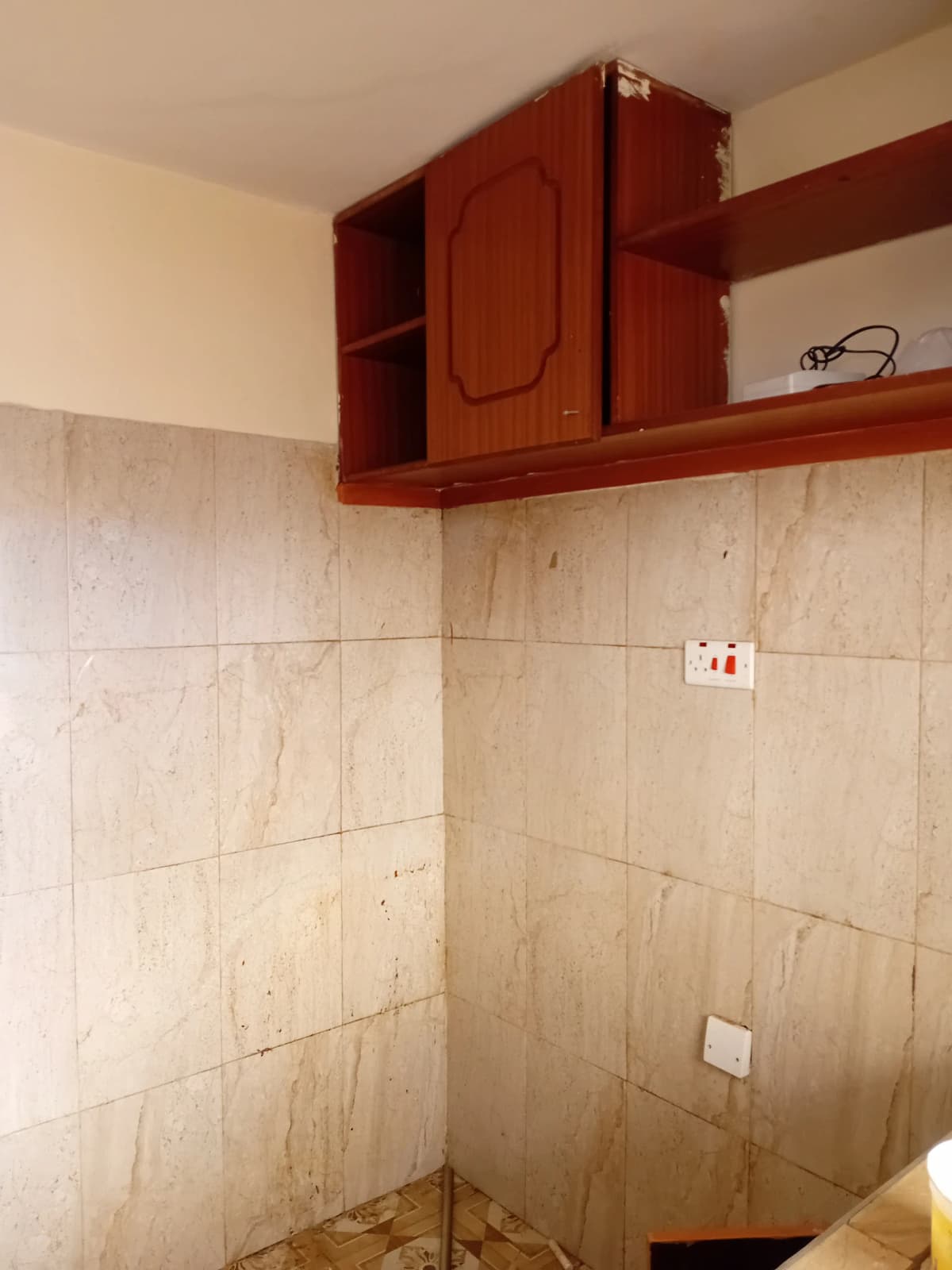 Bathroom with beige tile walls and red wooden cabinet