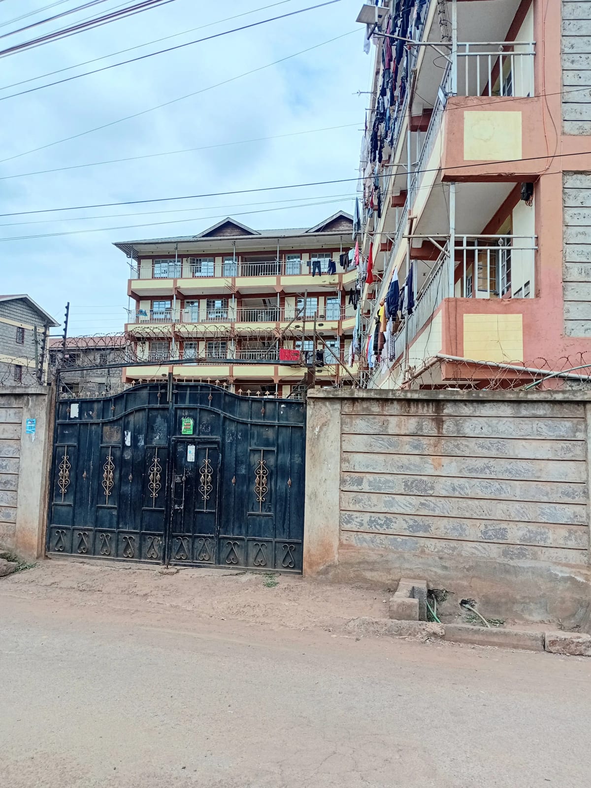 Multi-story residential building with blue metal gate entrance