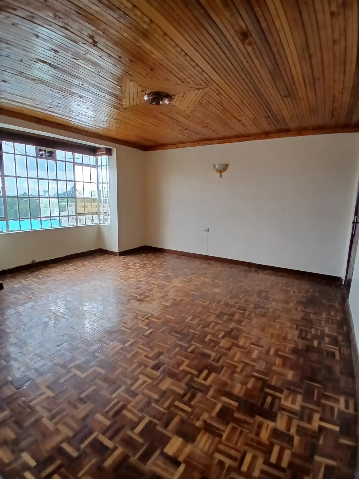 Spacious living room with wooden ceiling and parquet flooring