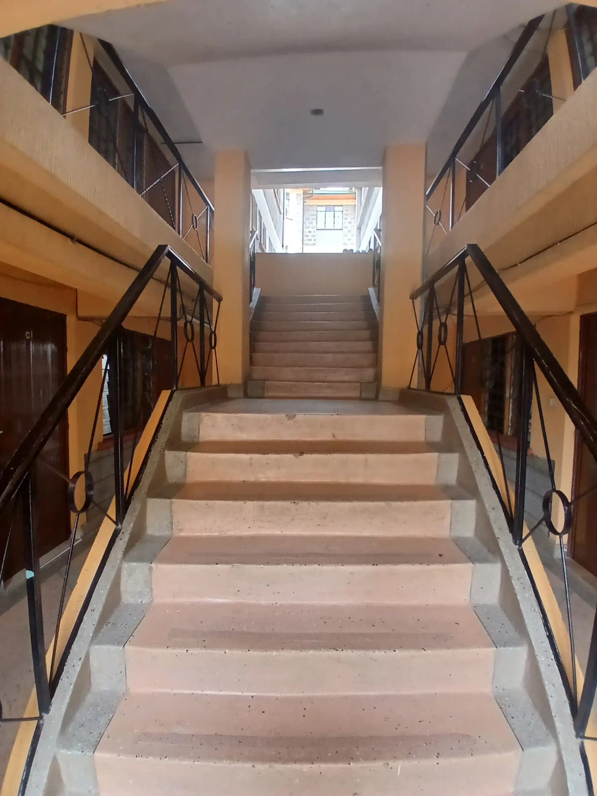 Multi-story stairwell with railings and ground floor entrance