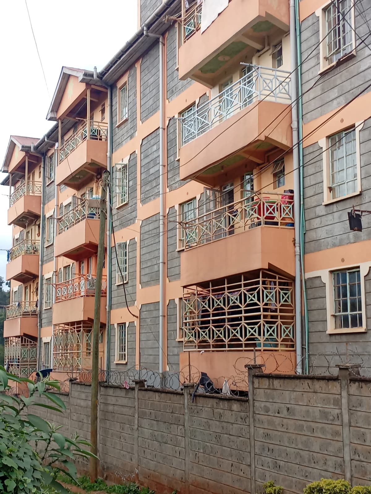 Multi-story residential building facade with balconies and gate
