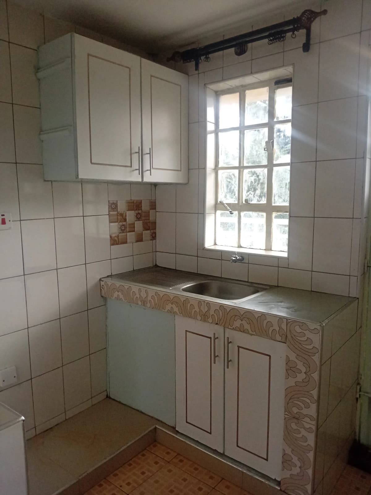 Compact kitchen with white cabinets and ceramic tile backsplash