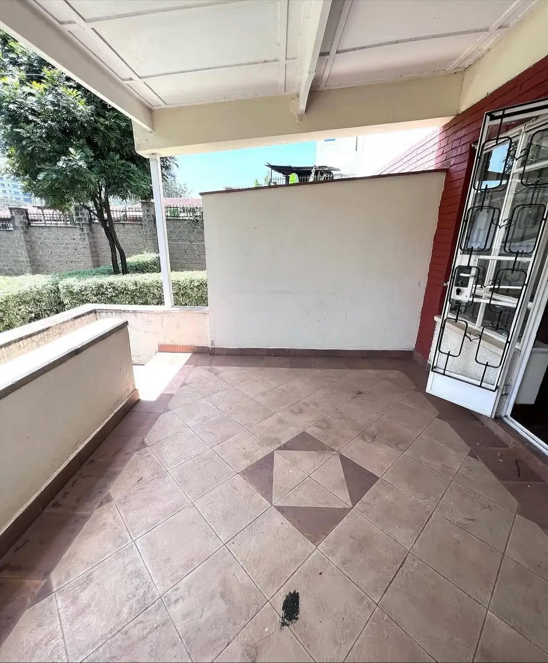 Covered terrace with tiled floor and garden views