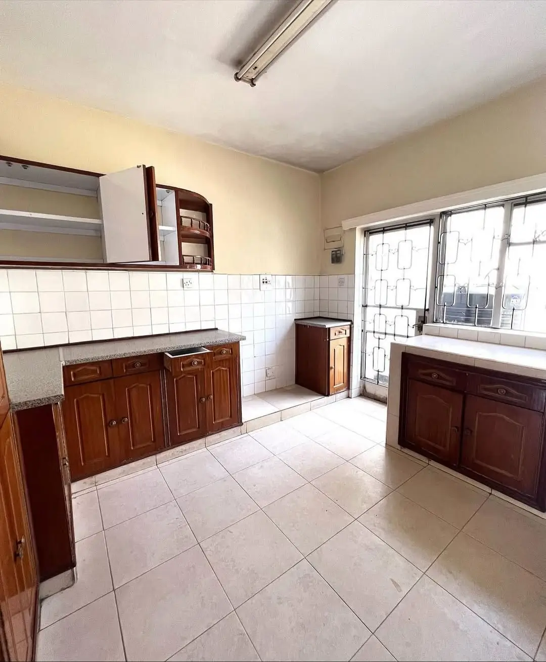 Spacious kitchen with wooden cabinetry and tiled flooring