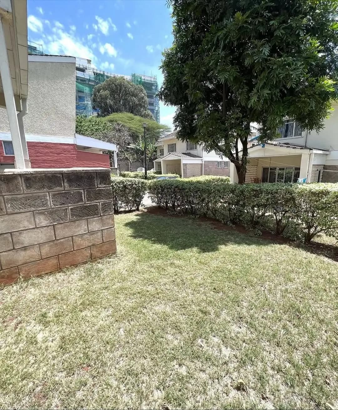 Residential compound grounds with manicured lawn and hedges